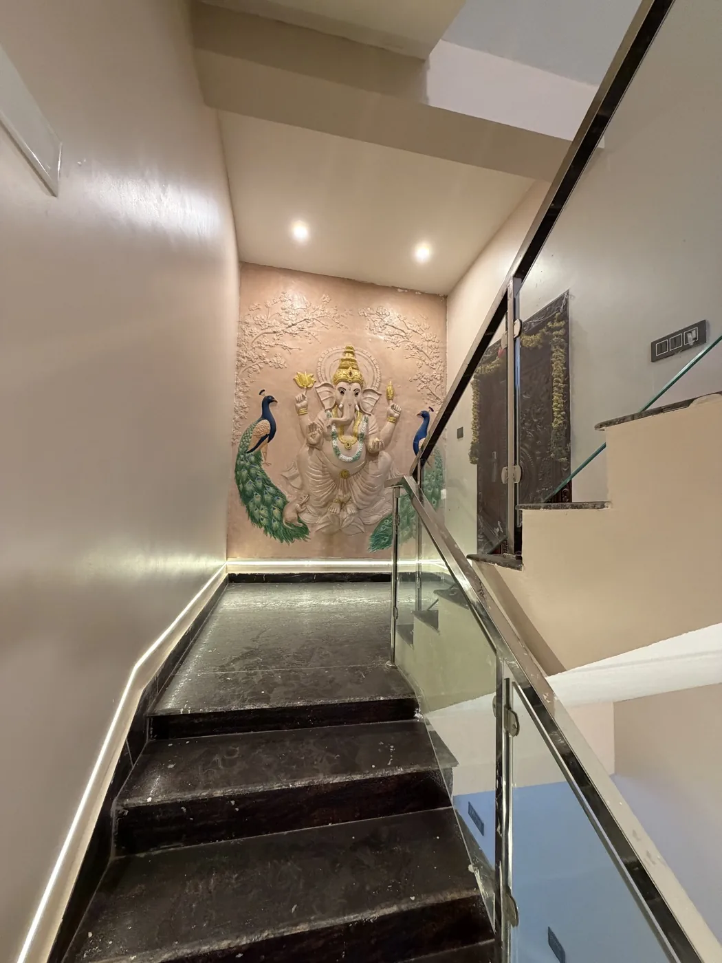 Staircase with sculpted feature wall and glass railing